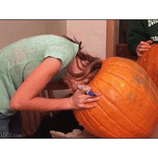 A girl gets her head stuck inside a pumpkin.